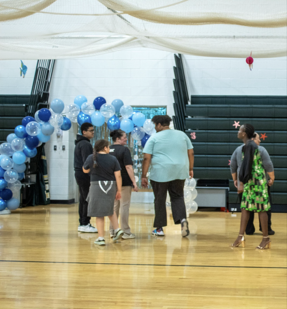 Students gather by the welcoming arch at the prom's entrance.